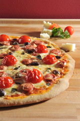 Pepperoni pizza with fresh cherry tomatoes and olives