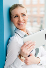 Smiling young business woman using tablet PC