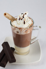 chocolate caliente con nata adornado con barquillo y sirope