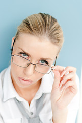 Portrait of a blonde young businesswoman looking over glasses