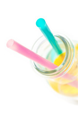 Cold lemon water in a  glass with two straws, isolated on white