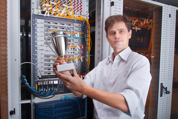 Naklejka na ściany i meble Network engineer in server room with the cup