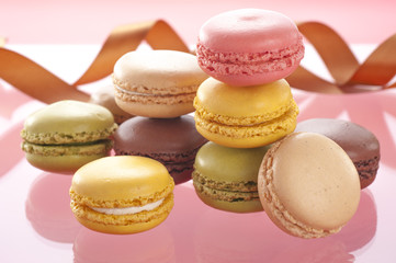 ピンク色の背景に複数のマカロン