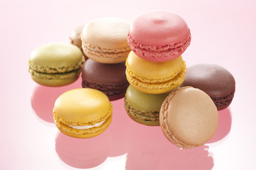 ピンク色の背景に複数のマカロン