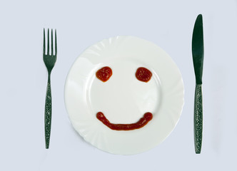 Smilie from ketchup on a white plate