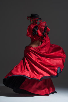 Woman in beautifull red dress dancing in a studio
