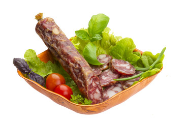 Ripe salami with salad, basil, onion and tomato