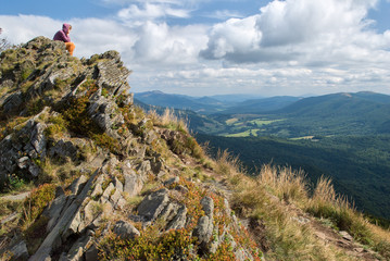 Naklejka premium Female tourist sitting and admiring the view in the mountains