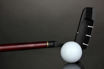 Golf ball and driver on grey background