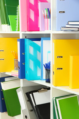 White office shelves with different stationery, close up