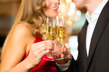 Man and woman tasting Champagne in restaurant