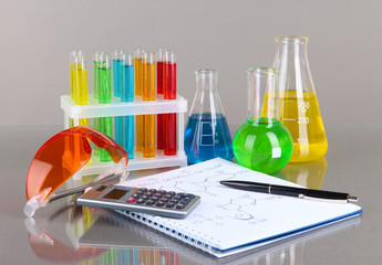 Test-tubes with colorful liquids on gray background