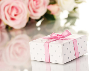 Beautiful gift on flowers background isolated on white