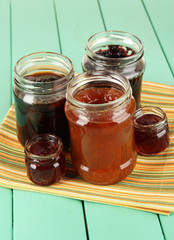Tasty jam in banks on table
