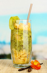 Delicious fruit smoothie on table on blue background