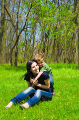 Naklejka na ściany i meble Young mother and son having fun in the woods