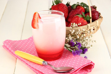 Delicious strawberry yogurt in glass on wooden table close-up