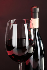 Wine in glass and wine bottle close-up on dark background