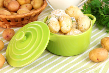 Tender young potatoes with sour cream and herbs in pan