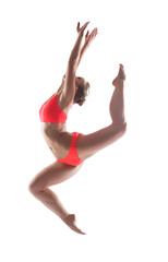 Fototapeta na wymiar Slender young gymnast posing in jump