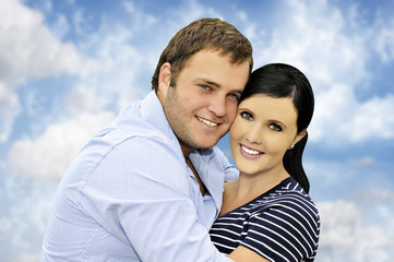 Beautiful happy  young couple with cloud background
