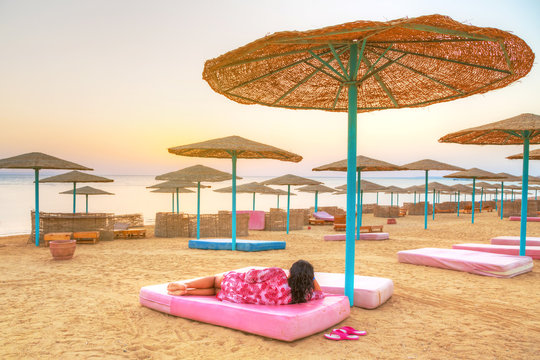 Relax under parasol on the beach of Red Sea at sunrise