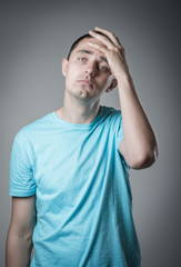 Desperate young man covering with his head in his hands