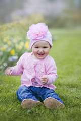 Happy little girl playing with flowers