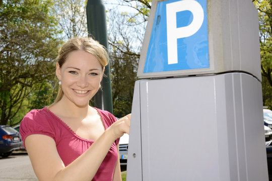 Junge Frau bedient Parkscheinautomaten