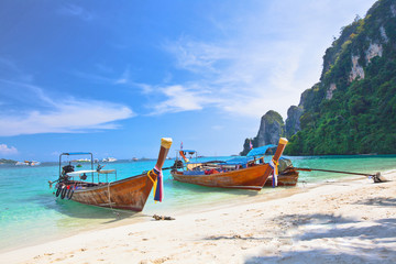 Fototapeta na wymiar Tropical island with two boats and a bright sky