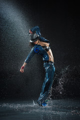 Wet dancing woman. Under waterdrops. Studio photo