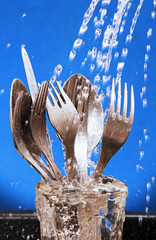 cutlery under running water.