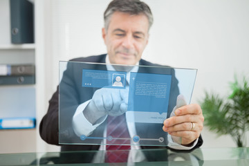 Businessman using futuristic touchscreen to view social media pr