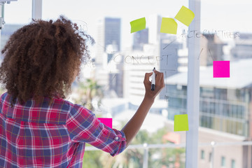 Woman drawing on flowchart with sticky notes