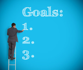 Businessman writing goals on a giant wall