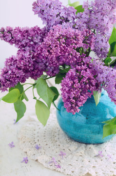 Beautiful lilac flowers in turquoise vase