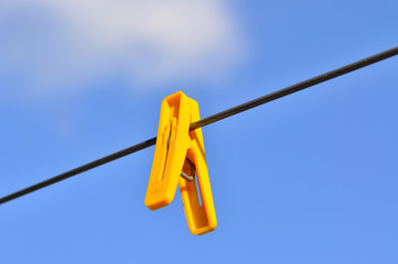 Clothes-line and pegs on blue sky background