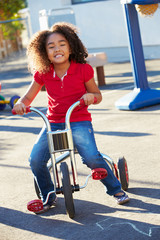 Child Riding Tricycle In Playground