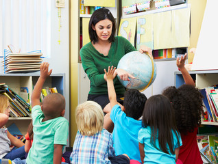 Elementary Pupils In Geography Class With Teacher