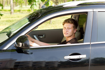 Smiling young man driving a car