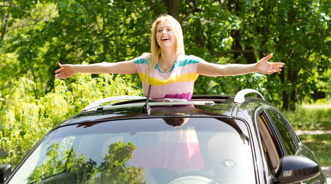 Playful Woman Standing In A Car Sunroof