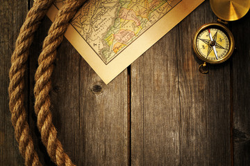 Antique compass and rope over old map