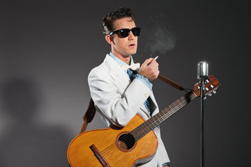 Retro rock and roll singer wearing white suit and black sunglass