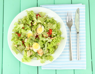 Caesar salad on white plate, on color wooden background