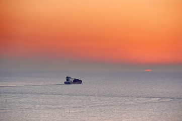 Naklejka premium cargo ship in sea at the sunset