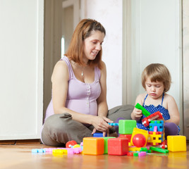 Obraz na płótnie Canvas pregnant mother plays with child in home