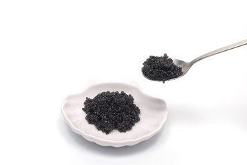 Caviar in saucer and spoon isolated on white