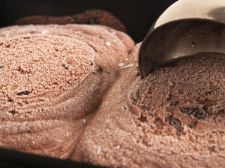 Helado de chocolate junto a una cuchara. Vista de frente y de cerca