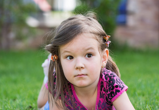 little girl laying down on grass