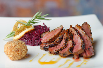 Duck breast fillet with red cabbage and potato ball.